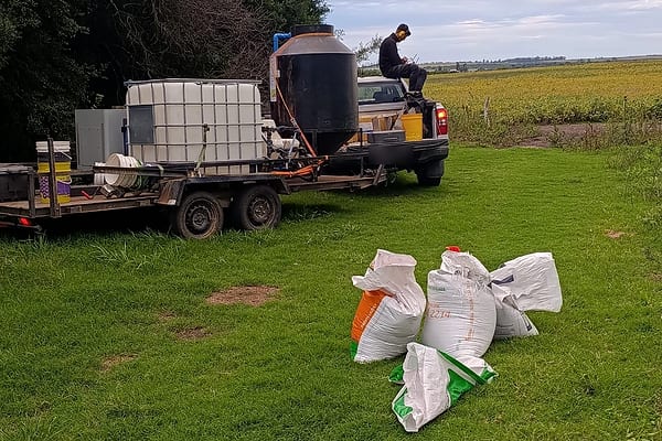 Versorgungsstelle am Feldrand: Anhänger mit Tanks, Pickup und Saatgutsäcke im Gras