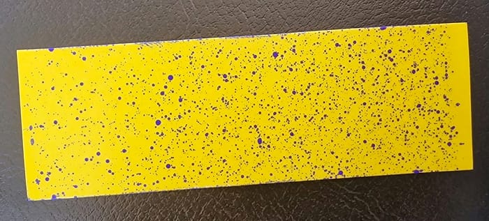 Gelbes wassersensitives Papier mit blauen Tropfenabdrücken