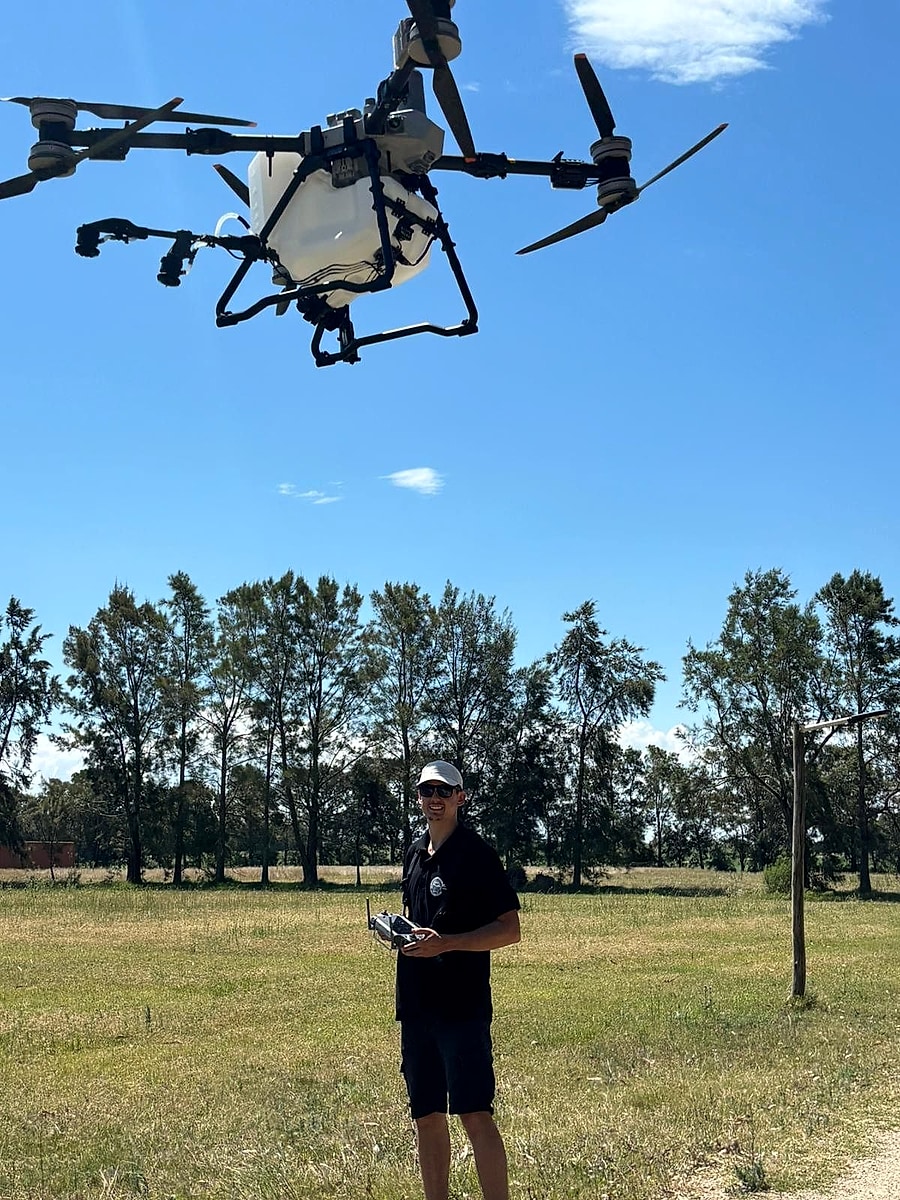 Stanley Kunz, Gründer von Kunz Agrotech, steuert die Agrardrohne DJI Agras T100 im Flug über einem Feld